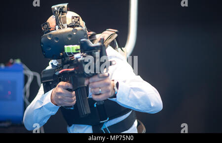 Stuttgart, Germany. 15th May, 2018. 15 May 2018, Germany, Stuttgart: An EnterVR employee using the company's VR Shield training simulator during the ITEC fair for military and weapons technology. Credit: Sebastian Gollnow/dpa/Alamy Live News Stock Photo