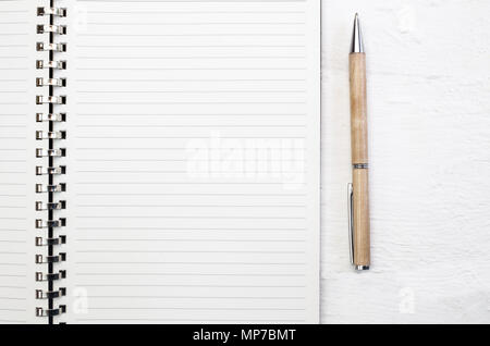 Blank note pad page close up on white deck table with pen Stock Photo
