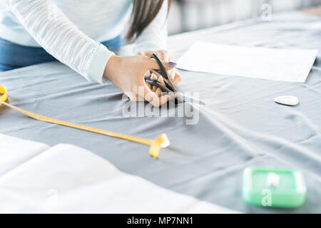 Young Woman Cutting Fabric Stock Photo