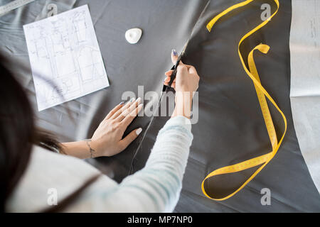 Young Woman Cutting Fabric Above View Stock Photo