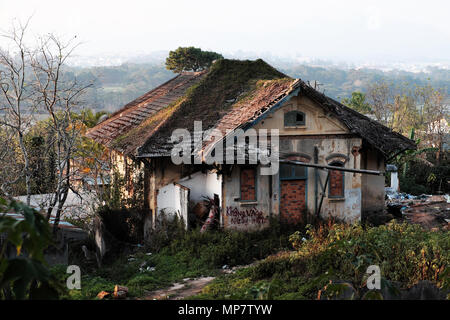 Dalat, Viet Nam- Feb 24, 2018: Damaged ancient villa in grass garden, mansion house with France architecture style degradation by time, Vietnam Stock Photo