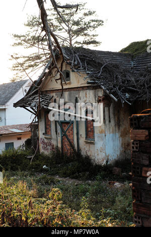 Dalat, Viet Nam- Feb 24, 2018: Damaged ancient villa in grass garden, mansion house with France architecture style degradation by time, Vietnam Stock Photo