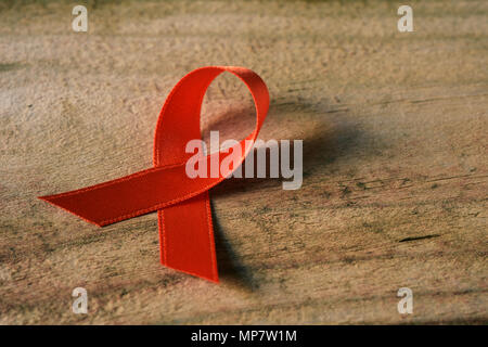 an orange ribbon, for multiple sclerosis awareness, on an wooden background with some blank space around it Stock Photo