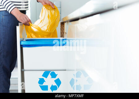 Smart person changing bin bag for recycling waste in eco friendly kitchen with sorting solution Stock Photo