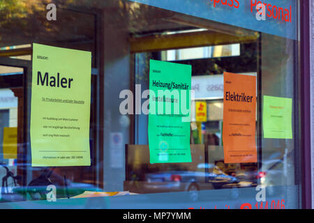 Munich, Germany - October 20, 2017:  Street announcements about available vacancies for a house painter, hospital attendant and electrician in window  Stock Photo