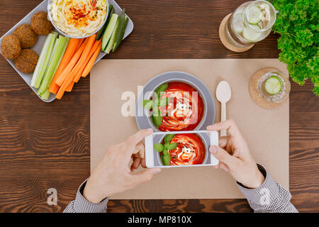 Man taking picture of tomatoe cream soup Stock Photo
