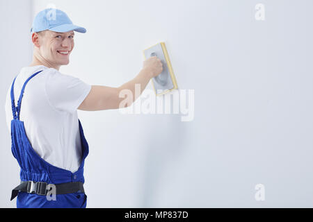 Handsome happy young man working as a interior construction worker Stock Photo