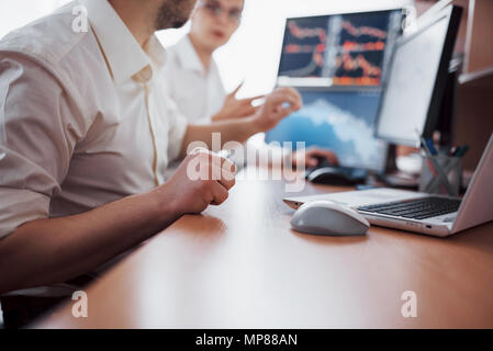 Analyzing data. Close-up of young business team working together in creative office while young woman pointing on the data presented in the chart with pen Stock Photo