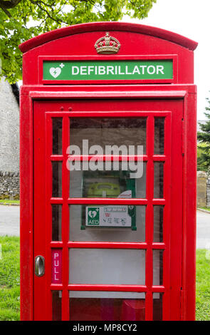 Traditional red telephone box being used to house a public defribillator, Sheldon, Derbyshire, England, UK Stock Photo