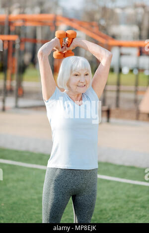 Alert woman exercising with hand weights Stock Photo