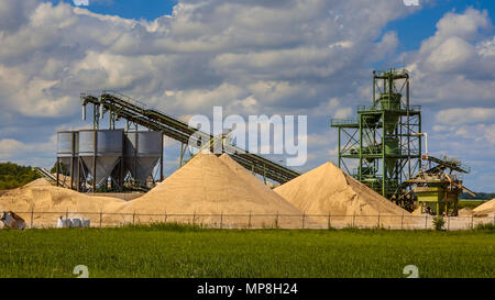 Sand mining terminal facility with conveyer belts and silos on a clouded summer day Stock Photo