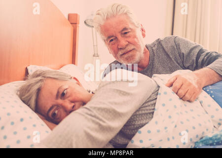 adult mature couple lifestyle waking up after the night. bedroom scene with window natural light. love forever together and nice life concept. white h Stock Photo