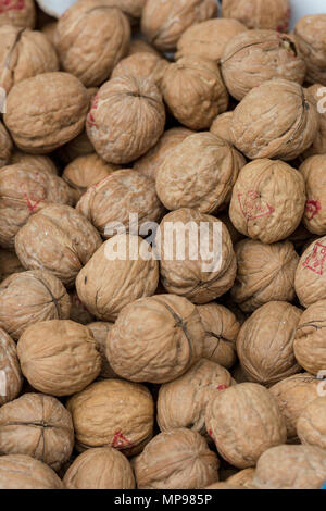 A large quantity of shell on walnuts on display at a market stall on borough market in central london. Walnuts and good cholesterol foods for heart. Stock Photo
