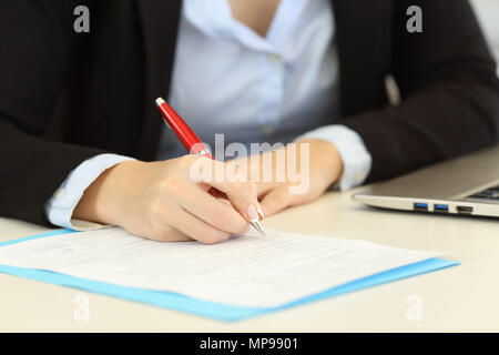 Front view close up portrait of an executive hands filling a form on a desktop Stock Photo