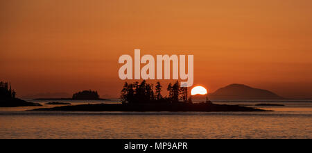 The sun sets while transiting Chatam Strait in the Inside Passage Stock Photo