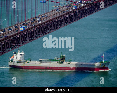 Ship sailing under April 25 bridge, Lisbon, Portugal Stock Photo