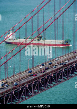 Ship sailing under April 25 bridge, Lisbon, Portugal Stock Photo