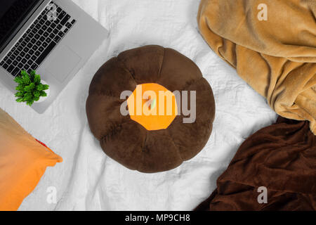 Blankets, pillows and laptop on bed. Stock Photo