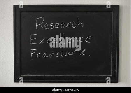 Research Excellence Framework written in white chalk on a wall mounted blackboard. Stock Photo