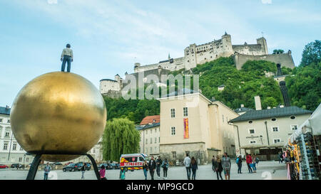 Kapitelplatz (Chapter Square) with the 'Sphaera' Sculpture by Stephan Balkenhol left and the HohenSalzburg medieval fortress above. Stock Photo