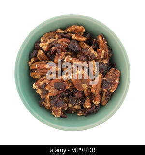 Top view of an old bowl filled with sugar glazed pecans and dried cranberries isolated on a white background. Stock Photo