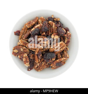 Top view of an small bowl filled with sugar glazed pecans and dried cranberries isolated on a white background. Stock Photo