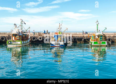 Fishing boats in the harbor of Kalk Bay in the early morning with fishermen in the background, Cape Town, Western Cape Province, South Africa. Stock Photo