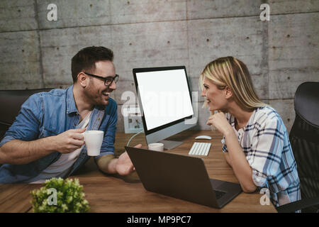 Young successful engineers colleagues talking while working on a new project in the office. Stock Photo
