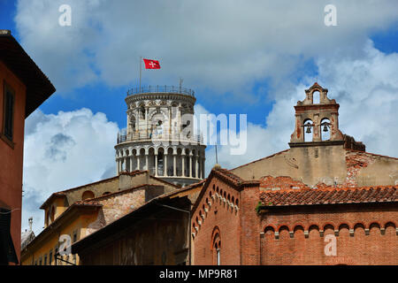 The famous Leaning Tower among clouds with Republic of Pisa ancient flag at the top, seen from the old historic center Stock Photo