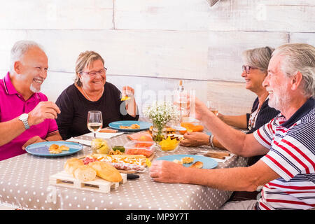 nice leisure time for group of two couples senior having lunch together with a lot of smile and laugh. friendship forever concept. Stock Photo