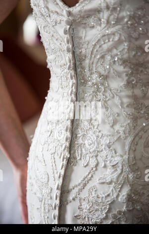 Wedding dress detail of buttons and lace on the back of a wedding dress with the bride in the dress on her wedding day,close up photo of dress only Stock Photo