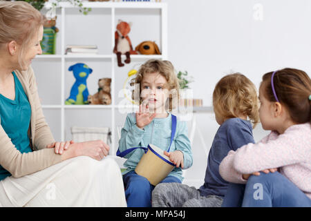 Little cute preschool boy playing the drum in kindergarten Stock Photo