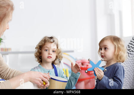 Preschool boy and girl playing the instruments in kindergarten Stock Photo
