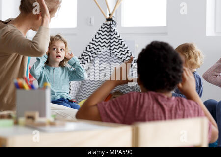 Teacher playing the game with her preschool pupils Stock Photo