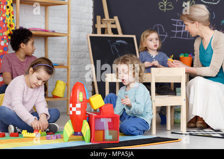 Group of preschool kids playing with toys on a carpet Stock Photo