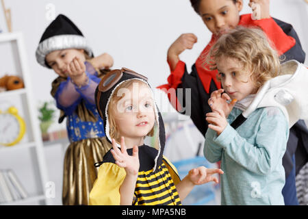 Kids in colorful costumes having fun on kindergarten party Stock Photo