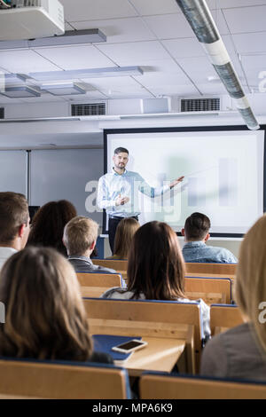 College teacher giving speech in lecture hall Stock Photo