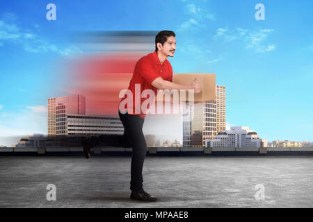 Cheerful asian courier man delivering package on the city Stock Photo
