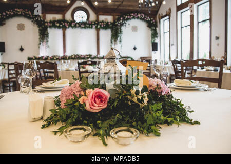 wedding table in the restaurant with a lot of transparent glasses, napkins and decoration of dishes. Stock Photo