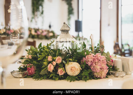 wedding table in the restaurant with a lot of transparent glasses, napkins and decoration of dishes. Stock Photo