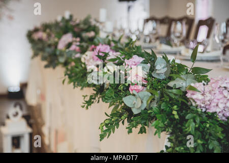 wedding table in the restaurant with a lot of transparent glasses, napkins and decoration of dishes. Stock Photo