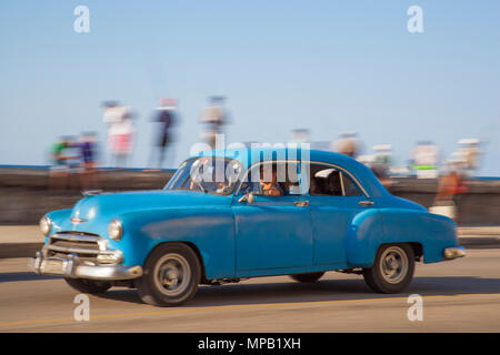 Classic American cars driving along the Malecon in Havana Cuba Stock Photo