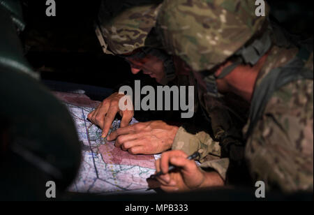 U.S. Army Master Sgt. Josh Horsager and Capt. Michael Rose, 75th Ranger Regiment Rangers, check the map during an event during the Best Ranger Competition 2017 in Fort Benning, Ga., April 8, 2017. The 34th annual David E. Grange Jr. Best Ranger Competition 2017 is a three-day event consisting of challenges to test competitor's physical, mental, and technical capabilities. Stock Photo