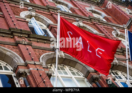 Shopping, sale red flag flying at Arnotts Department Store, brownstone building façade, on Henry Street. Dublin, Ireland, EU. Close up, low angle view Stock Photo