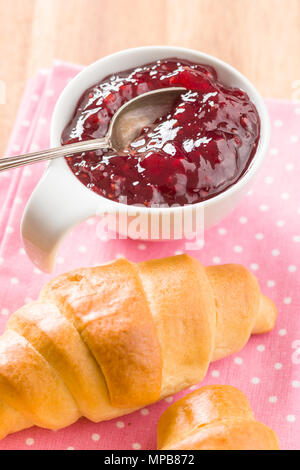 Raspberry jam jelly and croissant on napkin. Stock Photo