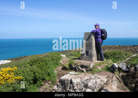 Walker on the South West Coast Path Enjoying the View From the Trig Point on Trevega Cliff Near St Ives, Cornwall, UK. Stock Photo