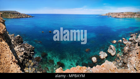 Colorful panorama with azure and turquoise color water with rocky seashore at Ghajn Tuffieha, Malta, EU Stock Photo