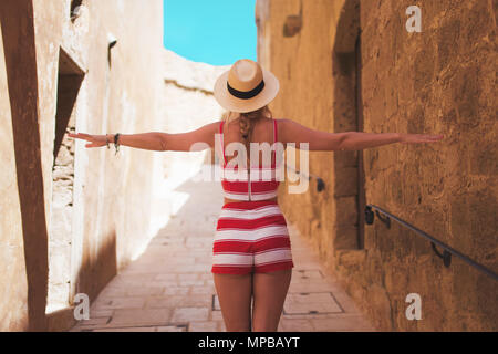 Woman in hat enjoying walking on mediterranean old street, Gozo, Malta Stock Photo