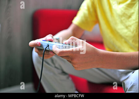 Children's hands holding game console controller Stock Photo