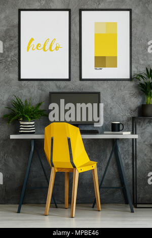 Canary yellow chair, desk and mock-up posters in bright office interior Stock Photo